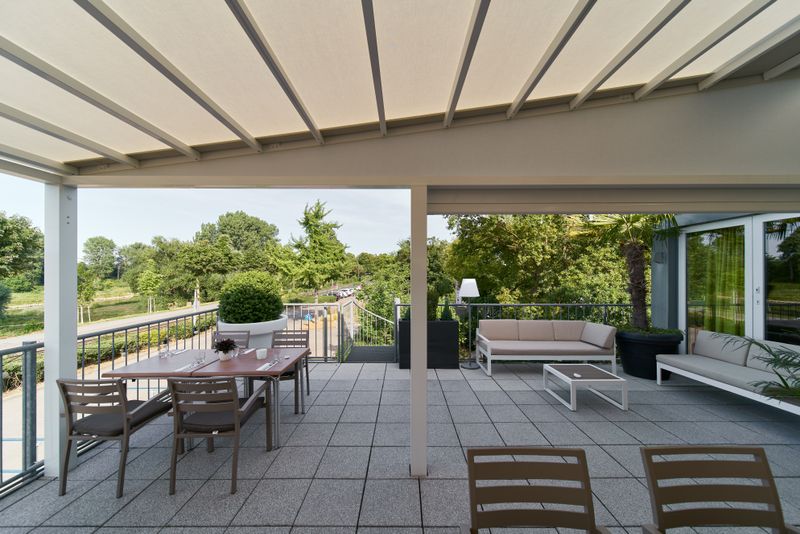 Reference picture of a pergola stretch with cream fabric cover and white frame over the outdoor area of the "bootshaus" in Mannheim, Germany